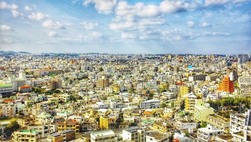 Aerial view of city against cloudy sky