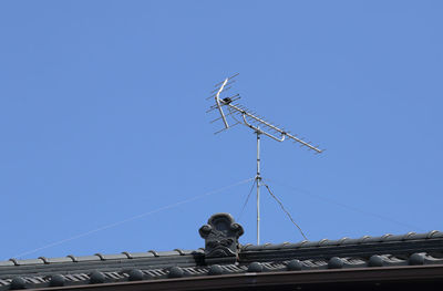 Low angle view of sculpture on roof against clear sky