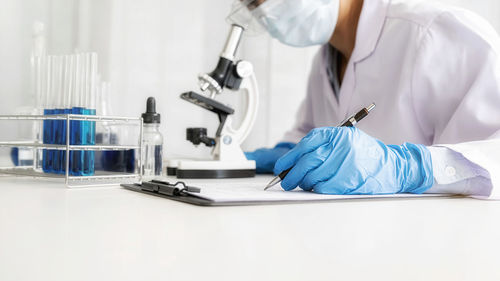 Midsection of doctor examining patient in laboratory