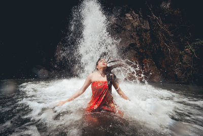 Woman splashing water in river