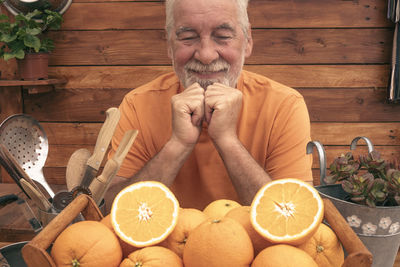 Smiling senior man looking at oranges