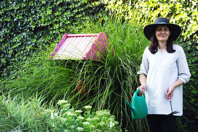 Portrait of man wearing hat standing against plants