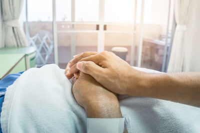 Close-up of man holding hands at home