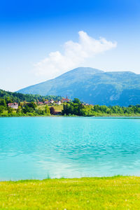 Scenic view of sea and mountains against blue sky