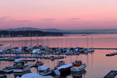 High angle view of boats moored at harbor during sunset