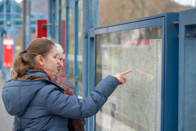 Granddaughter showing map to grandmother at railroad station platform