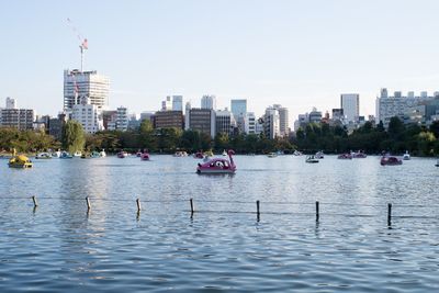 Boats in river in front of city