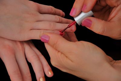 Cropped hands of woman painting friend nails