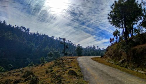 Road amidst trees against sky