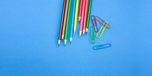 High angle view of colored pencils against blue background