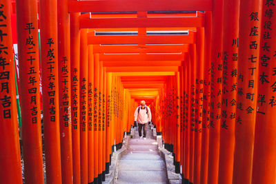 Rear view of people walking in temple outside building