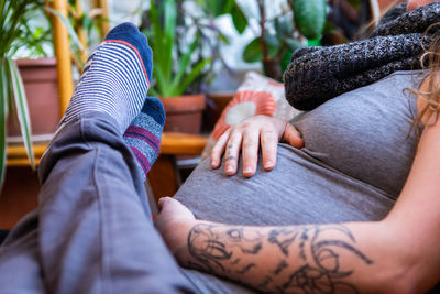 Midsection of woman with hands sitting on floor