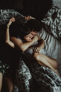 High angle view of couple relaxing on bed at home