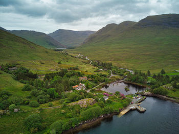 Scenic view of river by mountains against sky