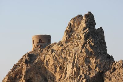 Historic tower in muscat, oman. an isolated towers trough rocks.