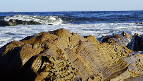 Close-up of rocks on beach against sky