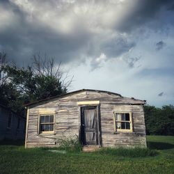 Abandoned house on field against sky