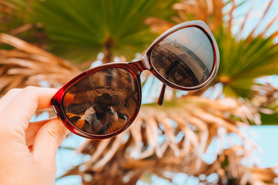 Close-up of woman hand holding sunglasses