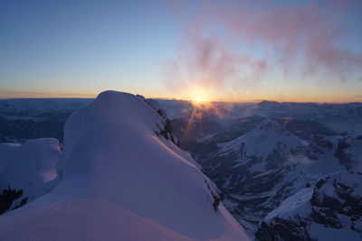 Scenic view of snowcapped mountains against sky during sunset