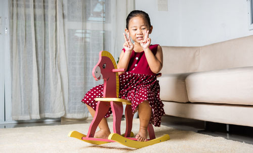 Young woman using mobile phone while sitting on sofa at home