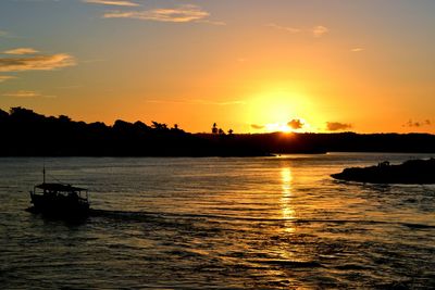 Silhouette of boats in lake during sunset