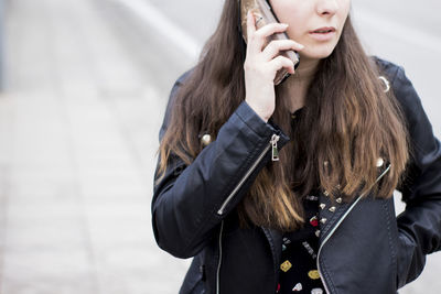 Midsection of woman using mobile phone in winter