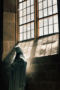 Rear view of woman standing against wall