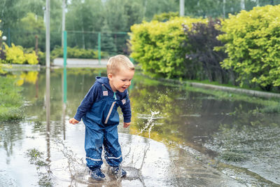 Boy standing in lake during rainy season