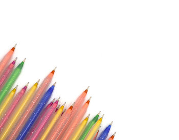 High angle view of multi colored pencils against white background