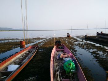 Boats moored on sea against clear sky