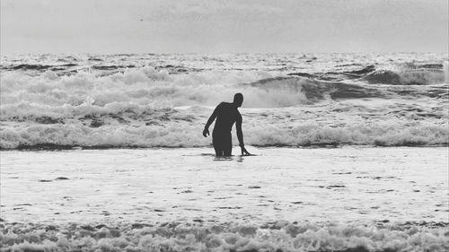 Surfer holding board on beach