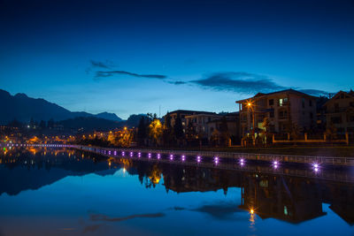 Reflection of buildings in lake at night