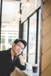 Portrait of young man drinking coffee at restaurant