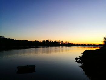 Scenic view of lake against clear sky during sunset