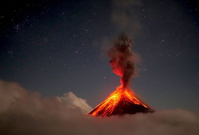 Low angle view of volcano against sky at night