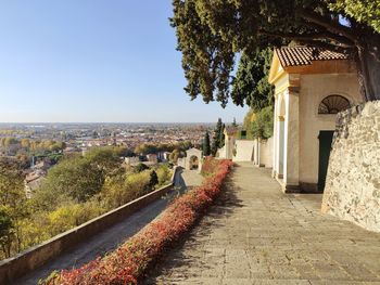 Footpath amidst buildings in town against sky