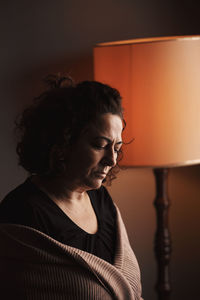 Portrait of woman against wall at home