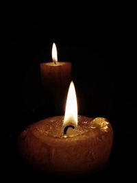 Close-up of lit candle in dark room