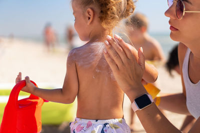 Rear view of shirtless boy at beach