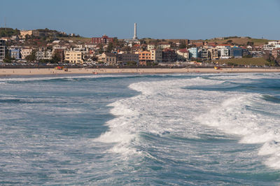 Scenic view of sea by buildings against clear sky