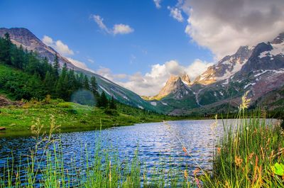 Scenic view of lake by mountains against sky