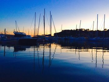 Boats moored at harbor against sky