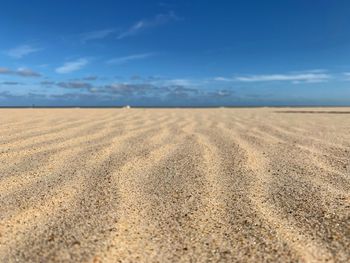 Surface level of sandy beach against sky