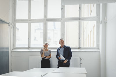 Businessman and businesswoman discussing in new office