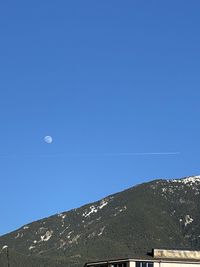 Low angle view of moon against clear blue sky