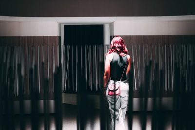 Rear view of woman standing with umbrella