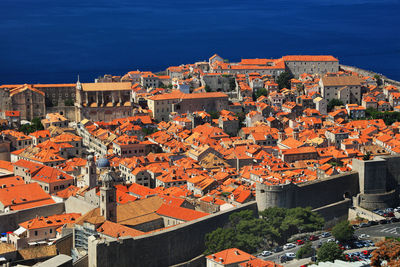 High angle view of houses in town against clear blue sky