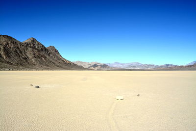 Scenic view of desert against clear blue sky