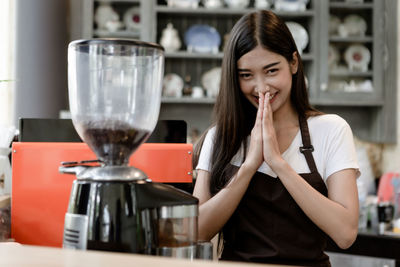 Woman standing with drink in kitchen