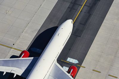 High angle view of airplane flying in airport runway